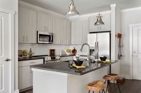 Murfreesboro apartment for rent - a kitchen with white cabinets and a black counter top at The Cannon, Murfreesboro