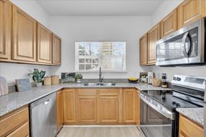 Leland apartment for rent - A kitchen with wooden cabinets and a granite countertop.