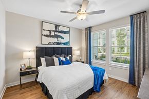 Knightdale apartment for rent - A bedroom with a large bed and a ceiling fan.