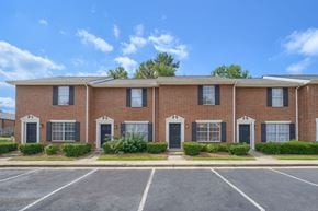 Commerce townhouse for rent - A row of red brick houses with black shutters.