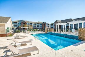 Columbus apartment for rent - A swimming pool surrounded by sun loungers and apartment buildings.
