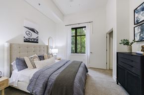 Atlanta apartment for rent - A bedroom with a large bed and a window with a view of trees.