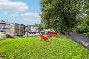 Doraville apartment for rent - A playground with red and blue slides is in the foreground of a grassy area.