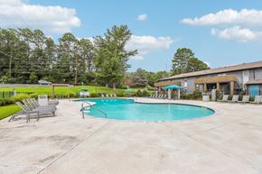 Doraville apartment for rent - A swimming pool surrounded by concrete and lounge chairs.