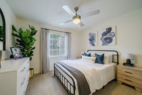 Smyrna apartment for rent - A bedroom with a bed, nightstand, and a plant.