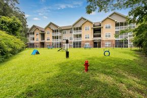 Goose Creek apartment for rent - A red fire hydrant sits in the middle of a grassy area in front of apartment buildings.