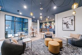 Atlanta apartment for rent - A modern lounge area with a variety of seating options and a large window.
