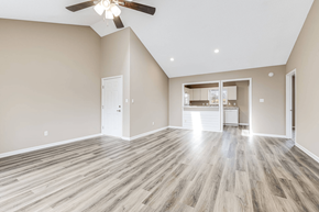 Asheville apartment for rent - an empty living room with a ceiling fan and a kitchen