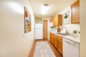 Urbandale apartment for rent - A kitchen with wooden cabinets and a white dishwasher.