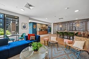 Columbus apartment for rent - A community lounge with a glass table and a blue couch.
