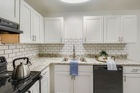 Nashville apartment for rent - A kitchen with white cabinets and a black stove top.