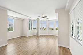 Sarasota apartment for rent - A room with a ceiling fan and wooden flooring.