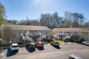 Asheville apartment for rent - a parking lot with cars in front of an apartment building