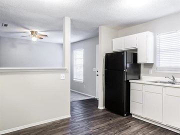 Fayetteville apartment for rent - A black refrigerator is in a kitchen with white cabinets.