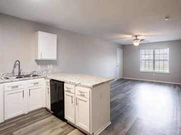Springdale apartment for rent - A kitchen with white cabinets and a marble countertop.