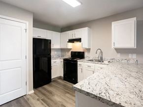 Springdale apartment for rent - a kitchen with white cabinets and a black