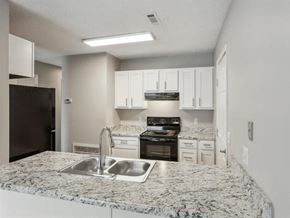Springdale apartment for rent - A kitchen with granite countertops and white cabinets.