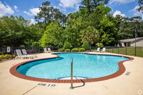 Thomasville apartment for rent - a resort style pool with chairs and a fence around it