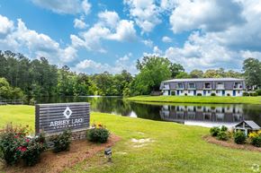 Thomasville apartment for rent - a large building with a lake and a sign in front of it