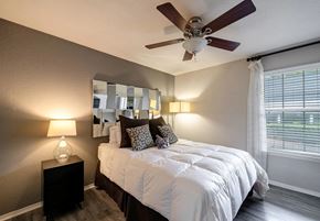 Atlanta apartment for rent - A bedroom with a bed, a ceiling fan, and a window with blinds.