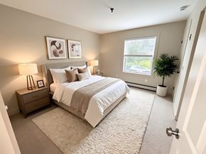Lebanon apartment for rent - A bedroom with a large bed, two lamps, and a potted plant.