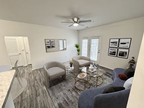 Columbus apartment for rent - A living room with a grey sofa, a grey armchair, a coffee table, and a ceiling fan.
