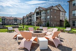 Louisville apartment for rent - an outdoor lounge area with chairs and a fire pit at the enclave at woodbridge apartments in at Century Belmont Station, Louisville, KY