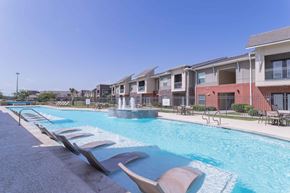 Portland apartment for rent - our apartments offer a swimming pool with chairs and a fountain at Century Palm Bluff, Portland, TX, 78374
