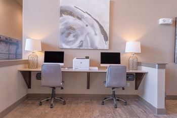 A desk with two computers and two lamps in a room