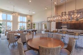 Portland apartment for rent - a large dining room with tables and chairs and a kitchen at Century Palm Bluff, Portland, Texas