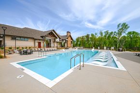 Hoschton apartment for rent - A large outdoor swimming pool with a slide and a building in the background.
