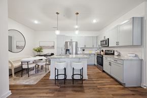 Murfreesboro apartment for rent - a kitchen with white cabinets and a large island with white chairs