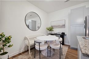Murfreesboro apartment for rent - a dining room with a white table and chairs and a round mirror