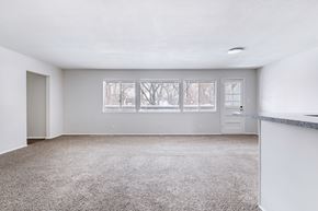 Prairie Village apartment for rent - A sparsely furnished room with a carpeted floor and a large window.