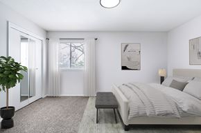 Prairie Village apartment for rent - A bedroom with a bed, a bench, and a plant.