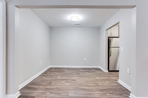 Stockbridge apartment for rent - Dining room with white walls and wood flooring and a refrigerator at Magnolia Place at Stockbridge Apartments, Stockbridge