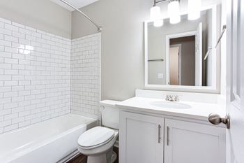A white bathroom with a sink and a toilet