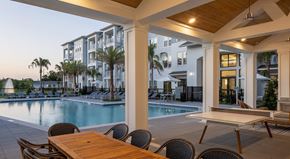 Clearwater apartment for rent - A poolside dining area with a table and chairs.
