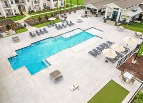 Murfreesboro apartment for rent - A large swimming pool surrounded by lounge chairs and umbrellas.