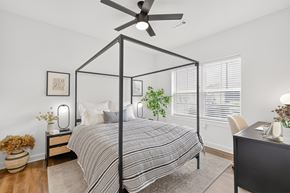 Murfreesboro apartment for rent - Bright primary bedroom featuring a ceiling fan, abundant natural light, walk-in closet, and private bathroom at Farmhouse Apartments in Murfreesboro.