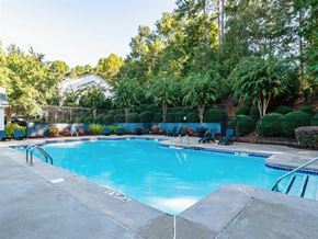 Canton apartment for rent - A large swimming pool surrounded by trees and a fence.