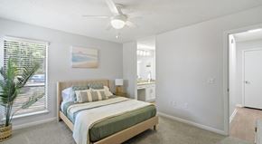 Columbus apartment for rent - A bedroom with a bed, a ceiling fan, and a painting on the wall.