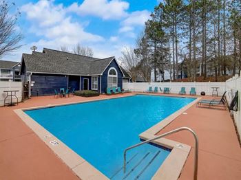 A swimming pool with a house in the background