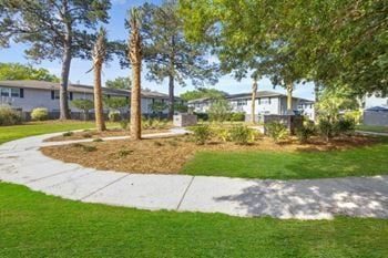 A walkway with trees and apartments in the background