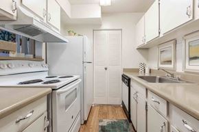Columbia apartment for rent - A kitchen with white appliances and cabinets. at Grove at St. Andrews, Columbia, SC, 29210