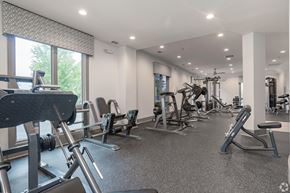Atlanta apartment for rent - A spacious gym with a variety of equipment and a large window.