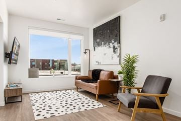 Columbus apartment for rent - A living room with a brown chair and a black and white rug.