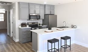 Moncks Corner apartment for rent - A kitchen with a white island and black stools.