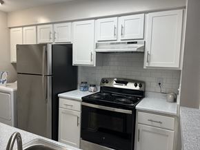 Atlanta apartment for rent - a kitchen with white cabinets and stainless steel appliances at The Hub at 934 Apartments, Georgia, 30349