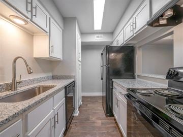 Indianapolis apartment for rent - A modern kitchen with a black refrigerator and stove top oven.